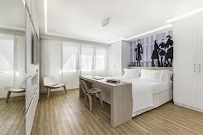 Ein modernes Schlafzimmer mit Bett, Schreibtisch und Stühlen.