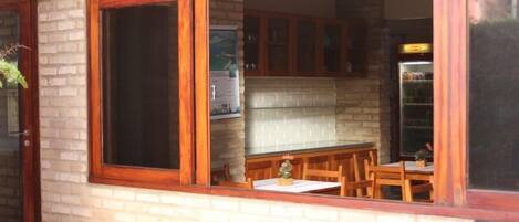 A kitchen with wooden cabinets, a brick wall, and a dining area with a table and chairs.