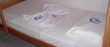 A single bed with a wooden frame and white bedding.