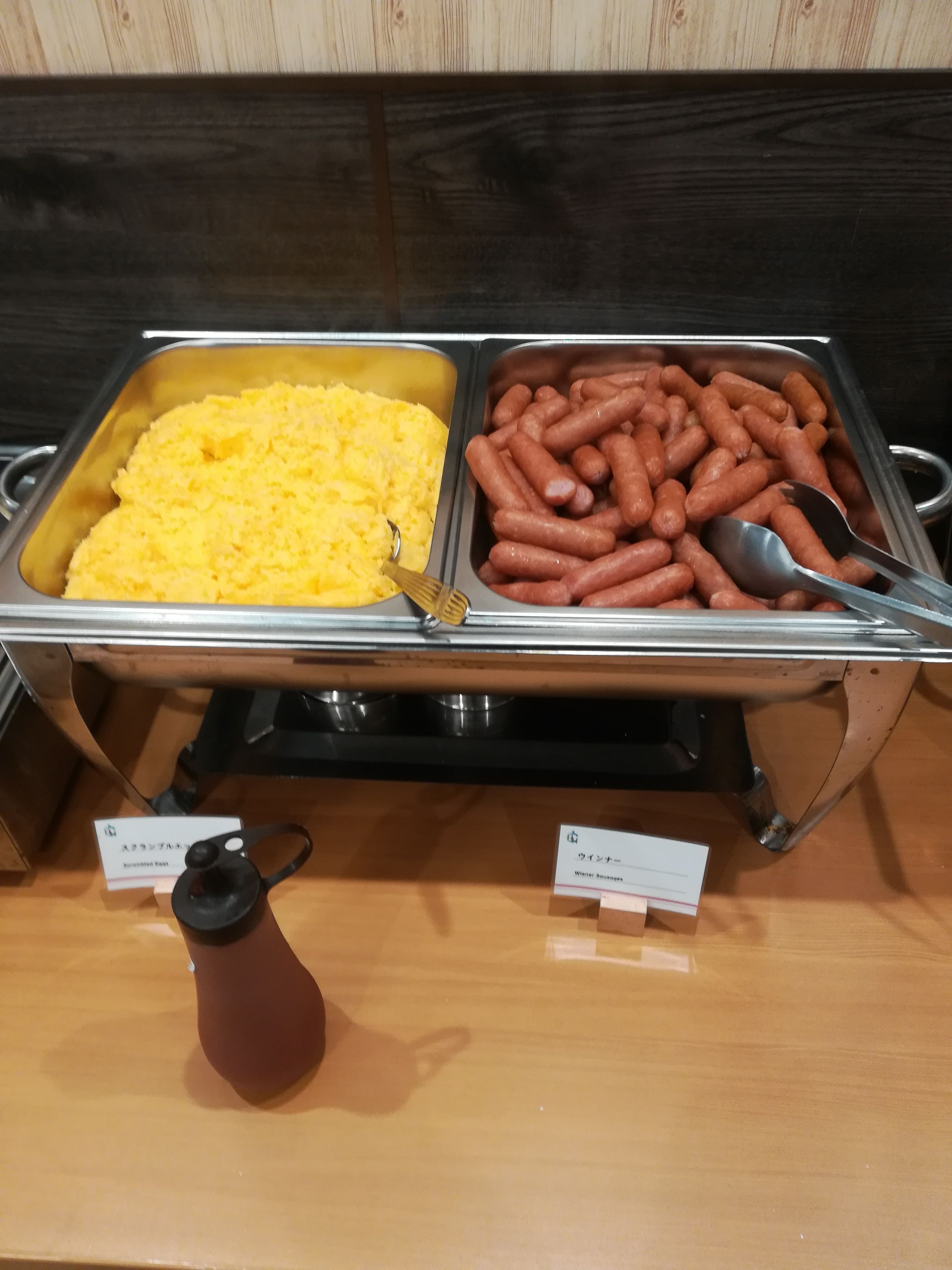 A buffet with yellow mashed potatoes and hot dogs.