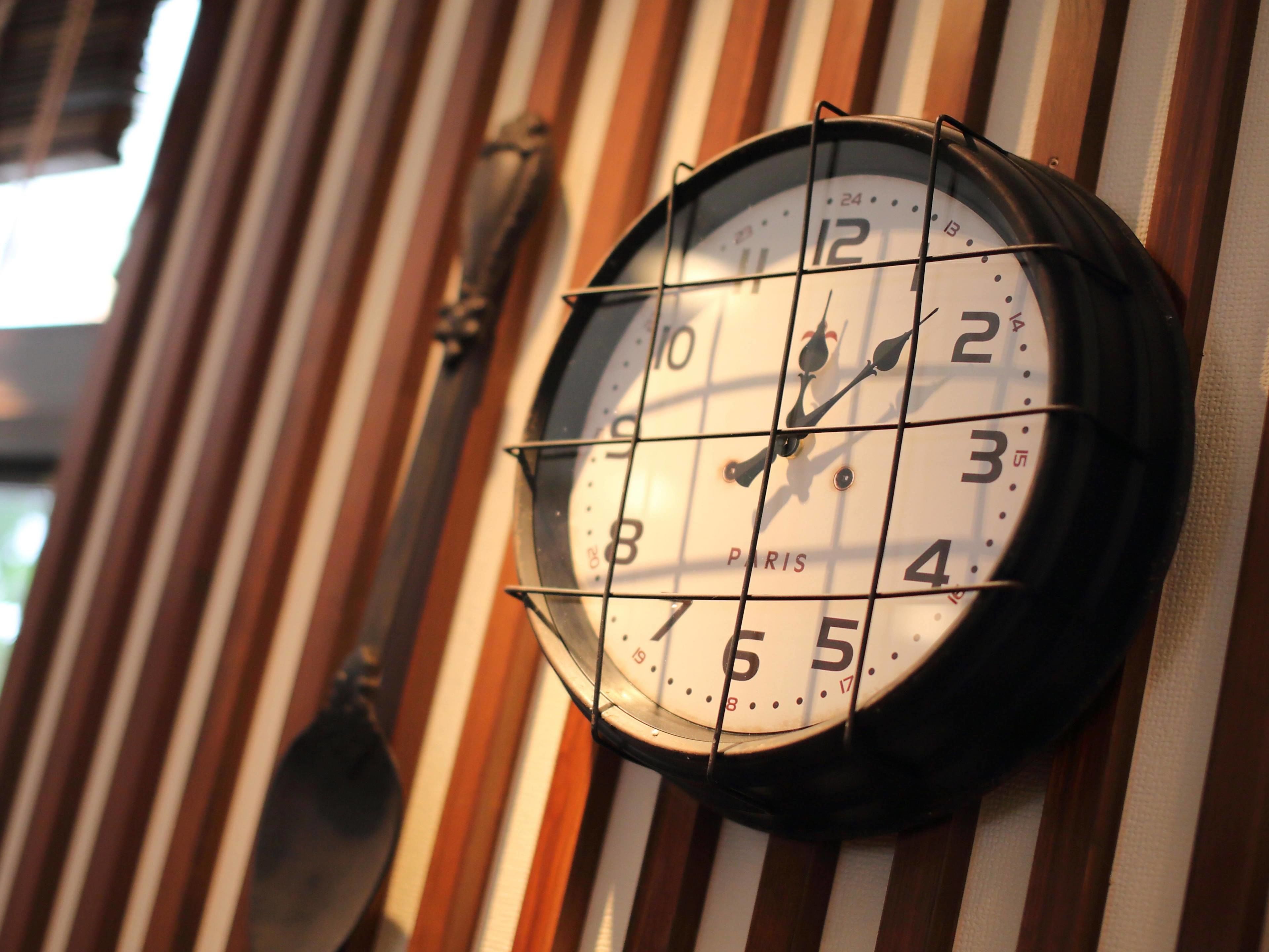 Un reloj de pared con diseño de cuadrícula y la palabra 'PARIS' escrita en él.