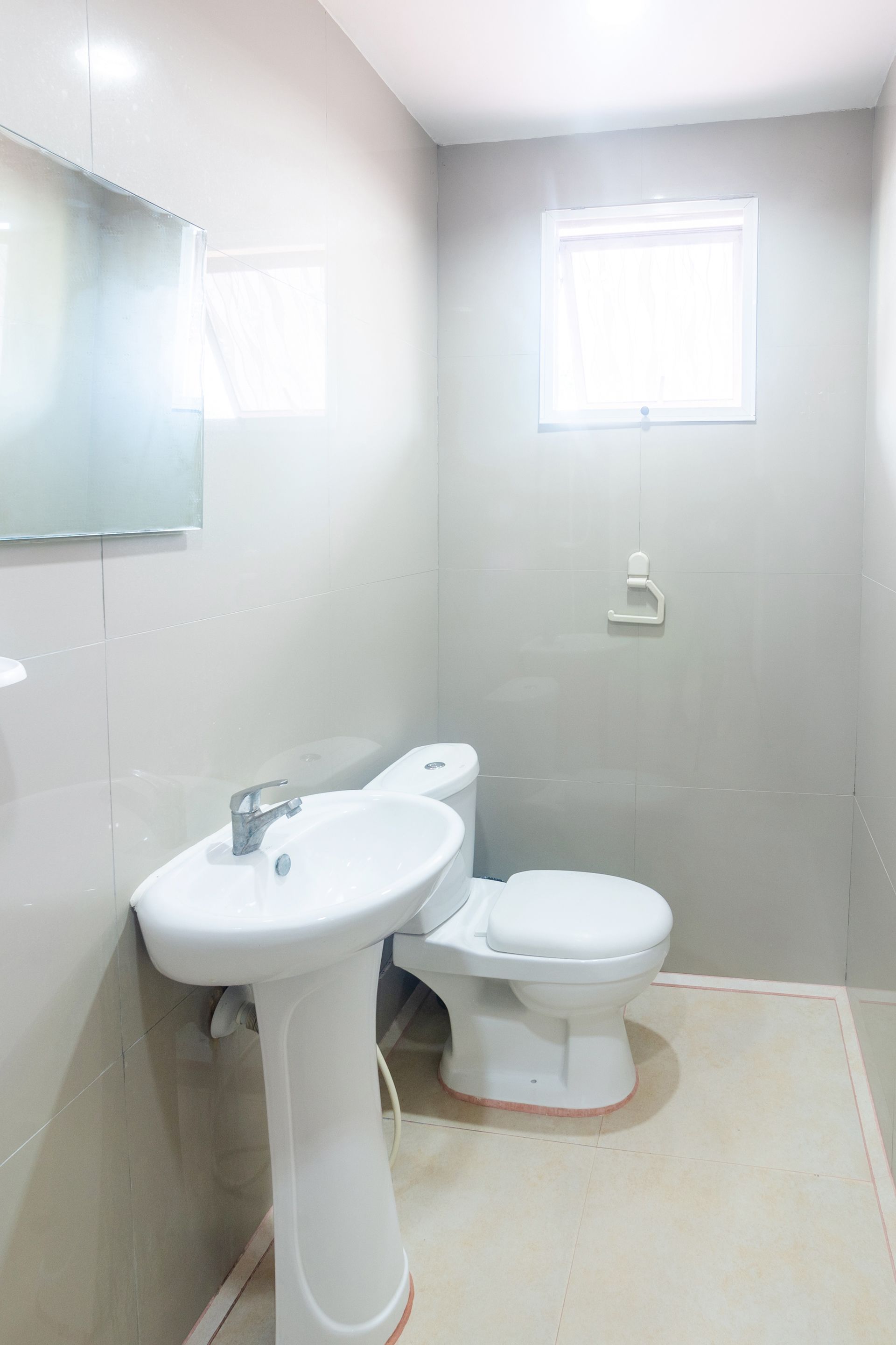 A bathroom with a white sink, toilet, and mirror.