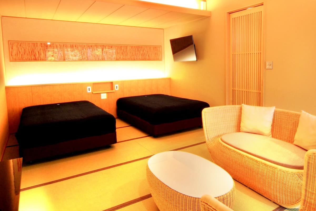 Une chambre avec deux lits, un canapé et une petite table.