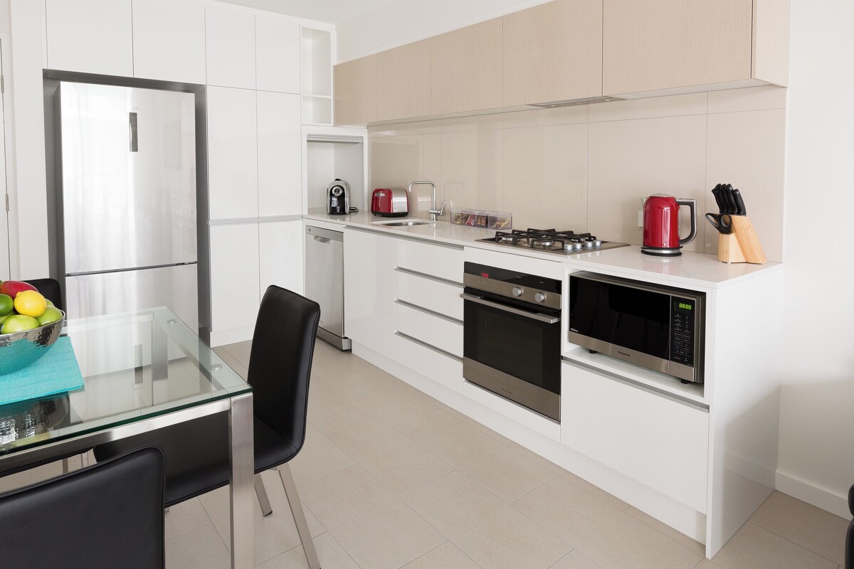 A modern kitchen with a refrigerator, microwave, stove, and dishwasher.