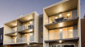 A modern multi-story residential building with balconies, large windows, and solar panels. - Hamilton Executive Apartments (Hamilton)