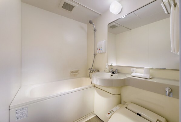 A bathroom with a bathtub, a sink, a mirror, and a toilet.