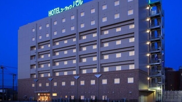 Un edificio de hotel de varios pisos con un cartel en japonés.
