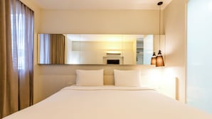 A hotel room with a large bed, a mirror, and a nightstand with a lamp. - Aera Rio de Janeiro Copacabana (Rio de Janeiro)