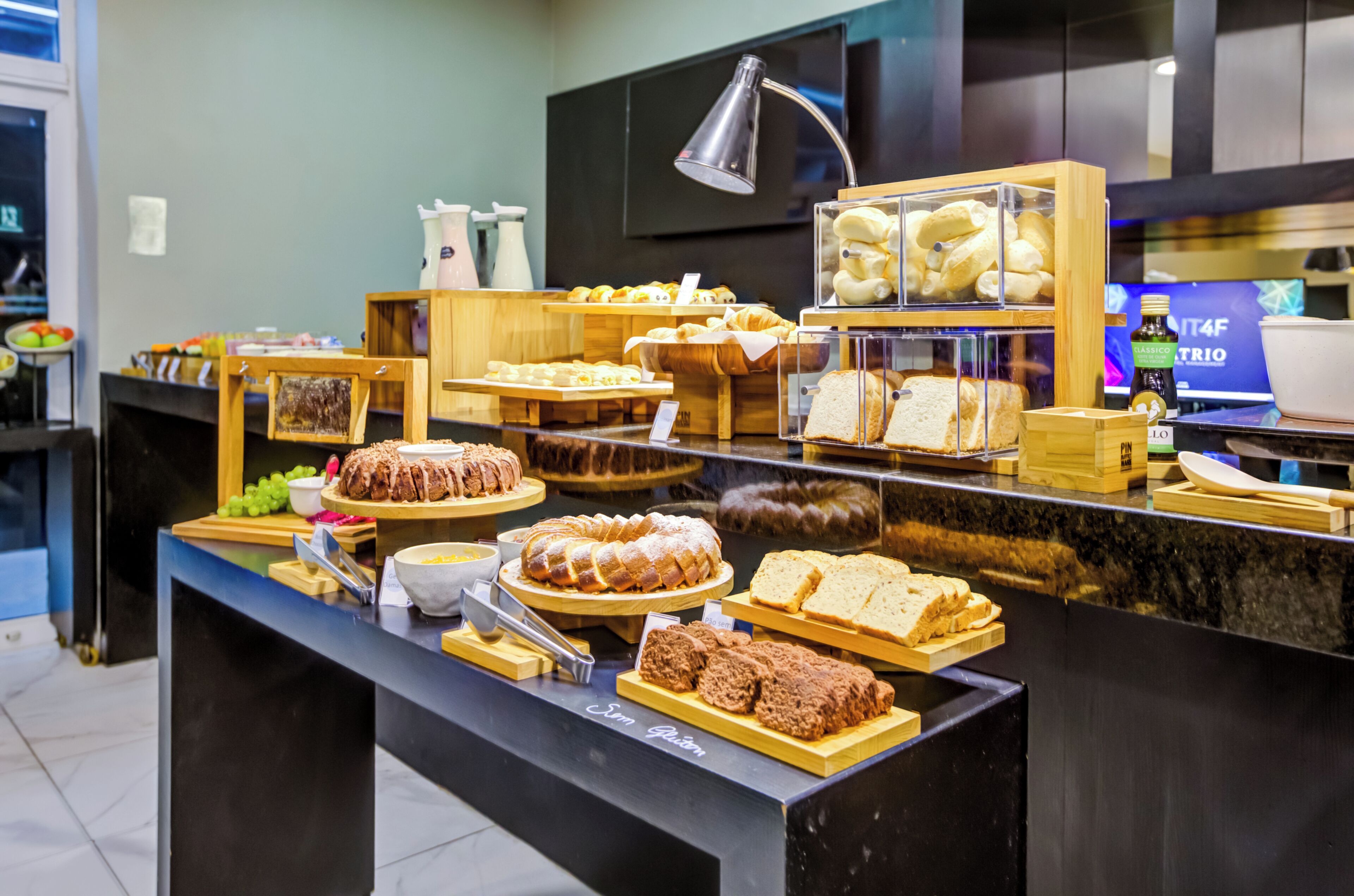 A buffet with various food items, including bread, pastries, and a cake.