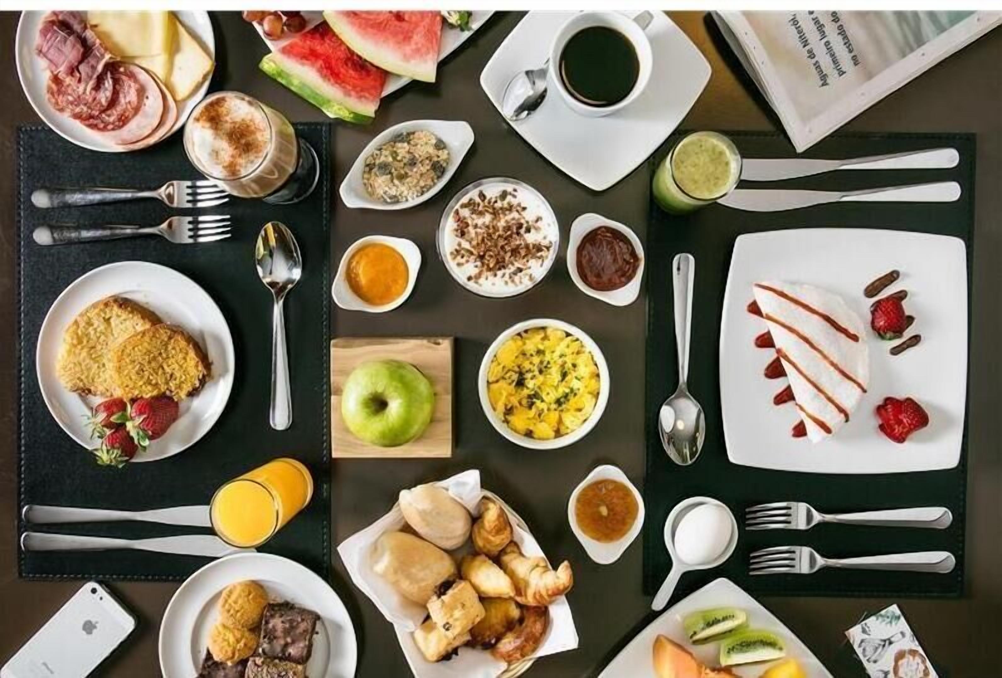 Una mesa con una variedad de platos y bebidas para el desayuno.