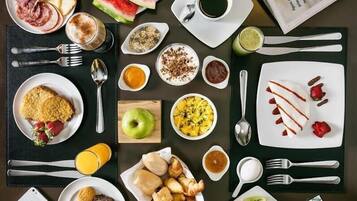 Una mesa con una variedad de platos y bebidas para el desayuno.