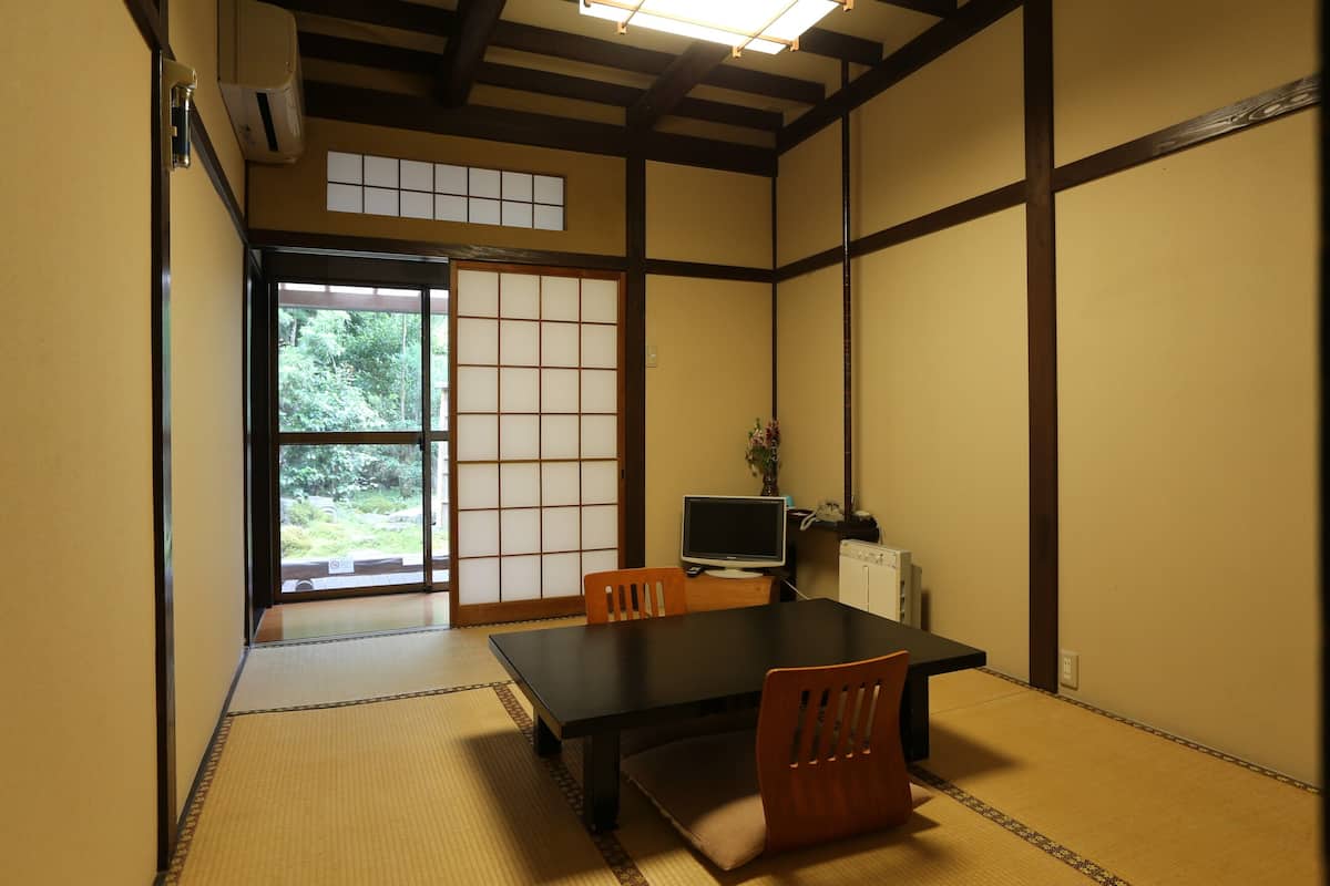 A traditional Japanese room with tatami flooring, a low table, and sliding doors.