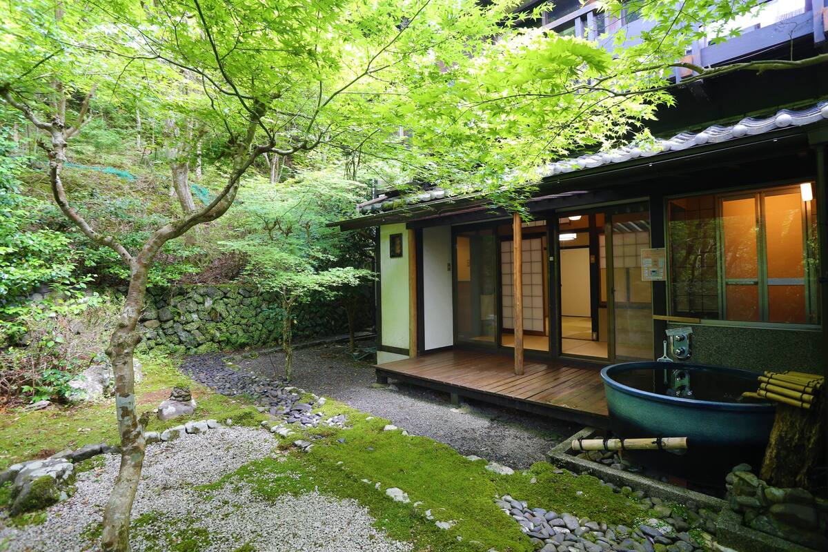 A traditional Japanese-style building with a wooden deck and a koi pond.