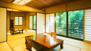 A traditional Japanese room with tatami flooring, a wooden table, and sliding doors. - Momijiya Bekkan Kawanoiori (Kyoto)