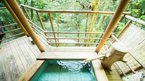 A wooden deck with a small pool, surrounded by a bamboo fence and lush greenery. - Momijiya Bekkan Kawanoiori (Kyoto)