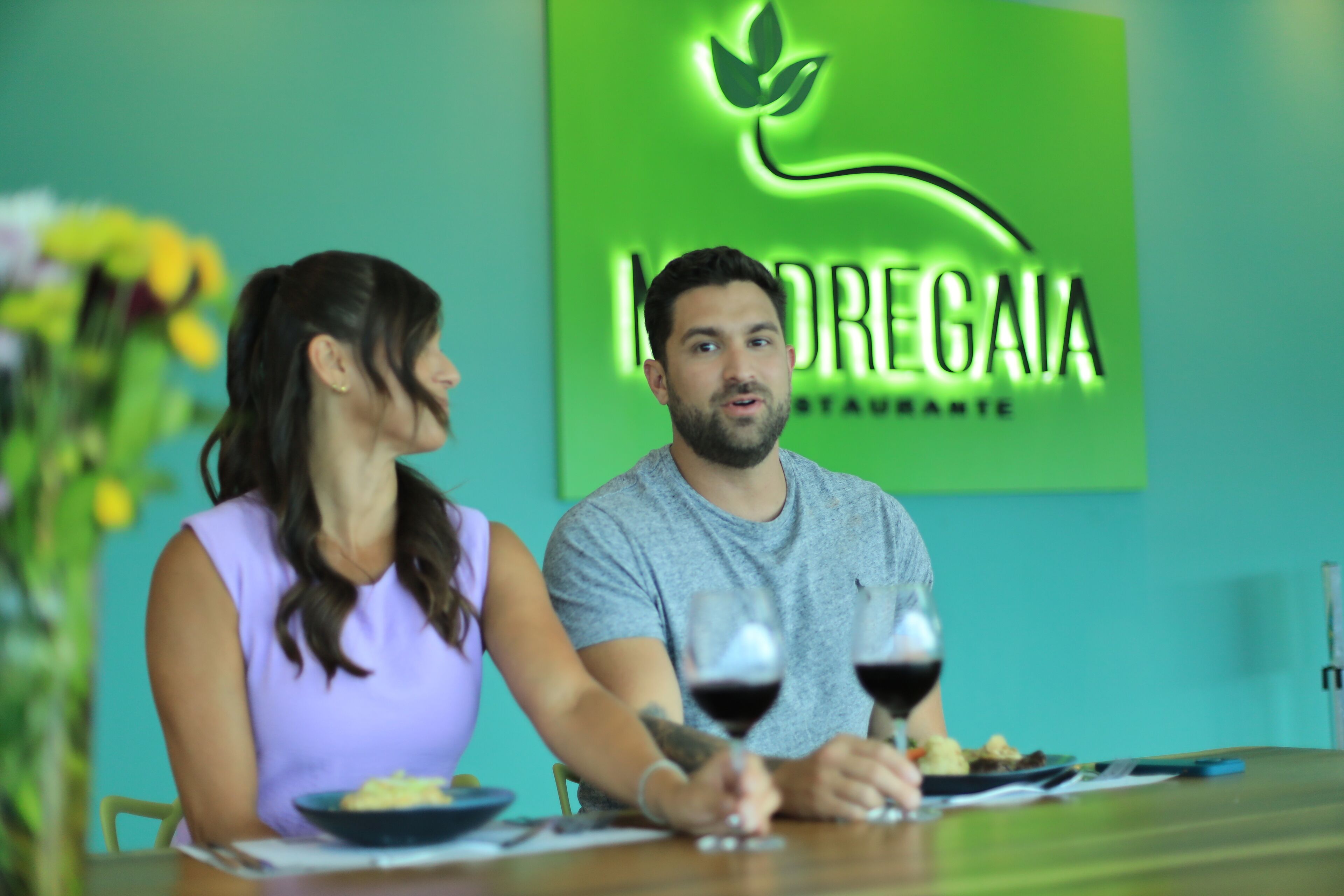 A restaurant interior with a green wall and a logo.