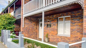 A brick building with a balcony, a signboard, and a potted plant. - Terrace on York (Launceston)