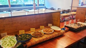 Un espace buffet proposant divers plats, chacun accompagné d’une étiquette, dans un cadre de restaurant.