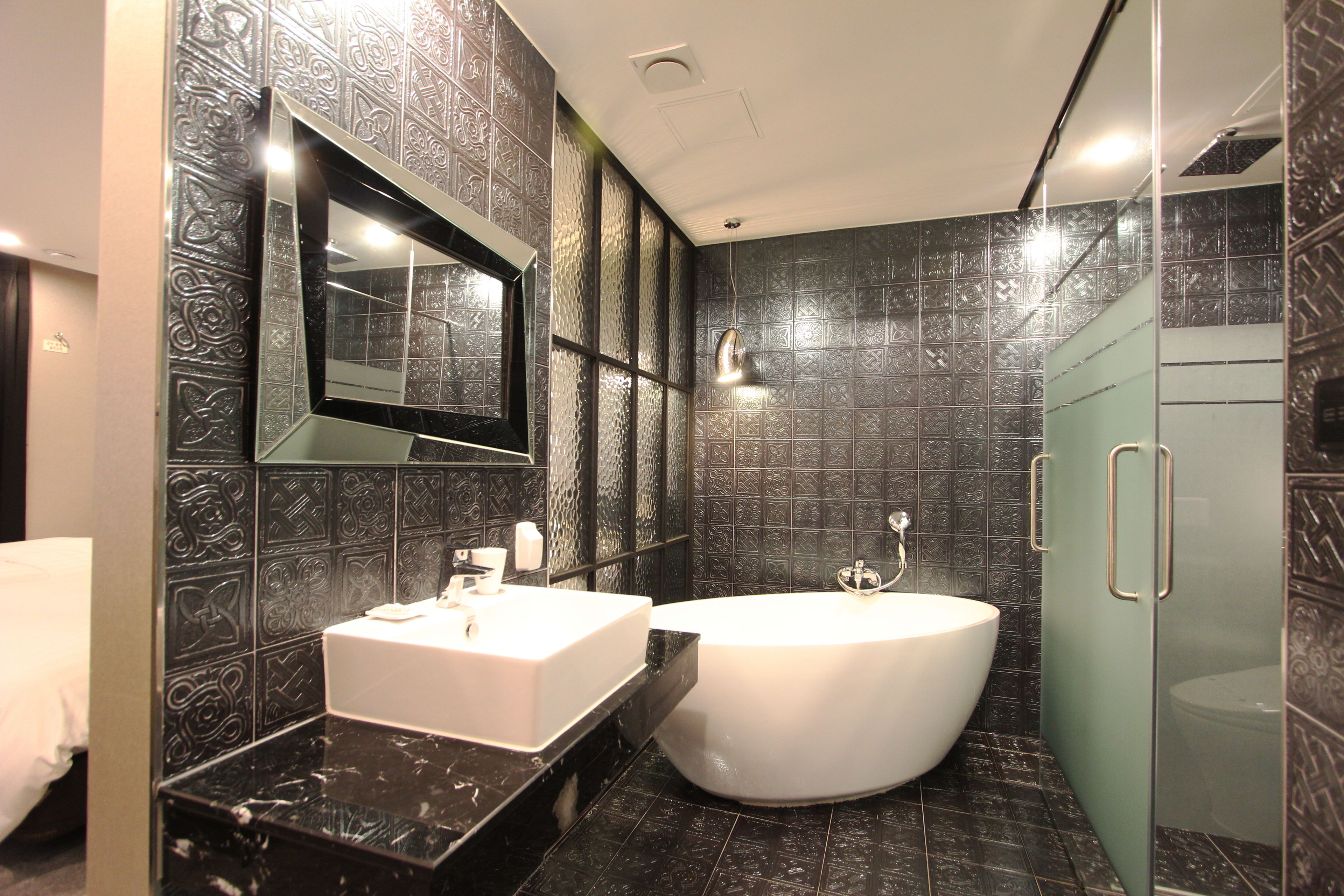 A modern bathroom with a white sink, a freestanding bathtub, and a glass shower enclosure.
