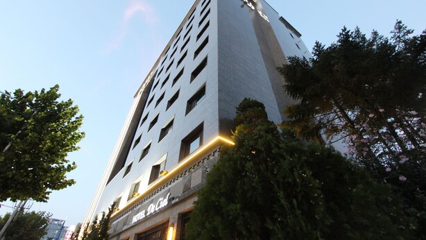 Un grand hôtel à étages, doté d’une entrée imposante et d’une enseigne indiquant qu’il s’agit d’un hôtel.