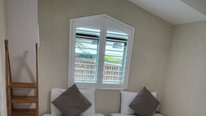 A room with two single beds, a wooden ladder, and a window with blinds. - Byron Bay Beachfront Apartments (Byron Bay)
