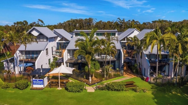 A beachfront apartment complex with multiple units, a swimming pool, and a well-maintained lawn. - Byron Bay Beachfront Apartments (Byron Bay)