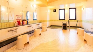 A large, well-lit bathroom with multiple sinks, a shower area, and a tiled floor.