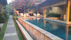 Alberca al aire libre y camastros 