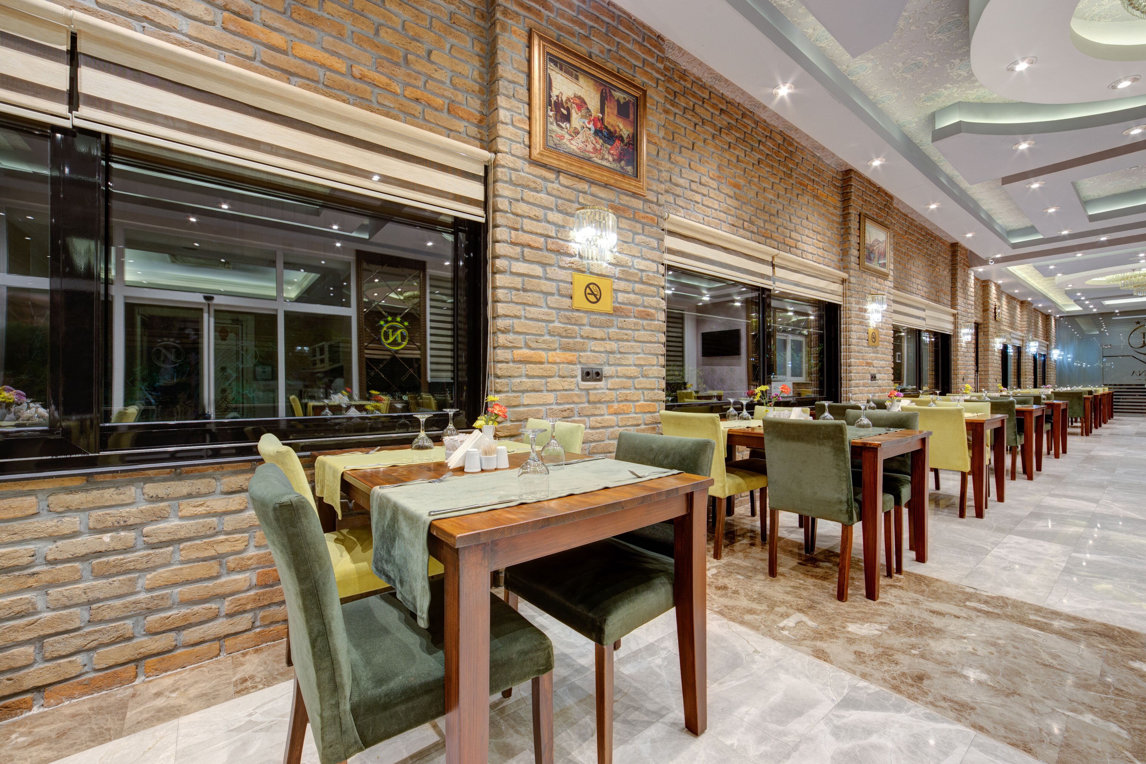A restaurant with brick walls, multiple dining tables, and chairs.
