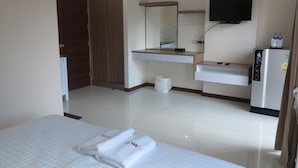 A hotel room with a bed, a wardrobe, a mirror, a television, a refrigerator, and a sink. - AAA Mansion (Hat Yai)