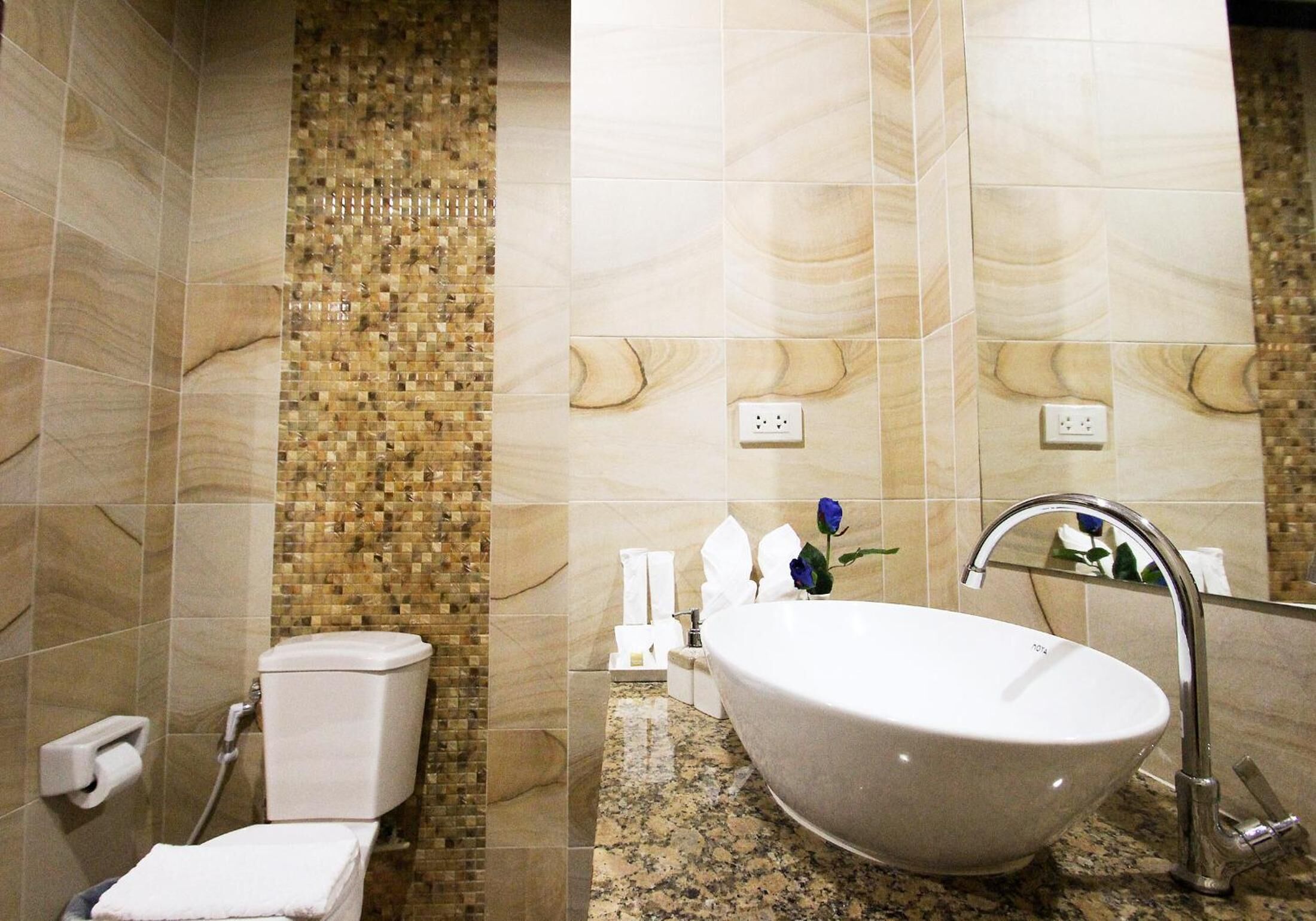 Ein Badezimmer mit Marmorboden, Waschbecken in Weiß und Toilette.