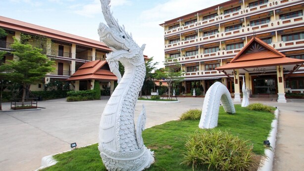 A building with a multi-story structure, a large white dragon sculpture in the courtyard, and a red-roofed entrance. - I Boutique Hotel (Pluak Daeng)
