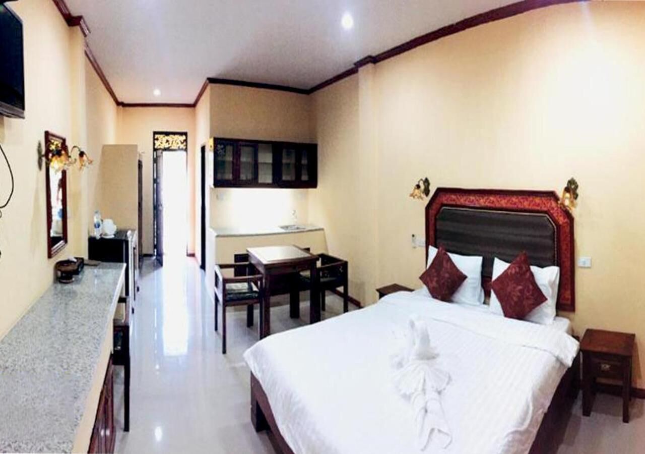 Una habitación de hotel con una cama grande, un escritorio y una silla.