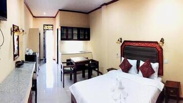 A hotel room with a large bed, a desk, and a chair.