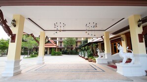 A covered courtyard with a central open space, columns, and a statue of a white animal. - I Boutique Hotel (Pluak Daeng)