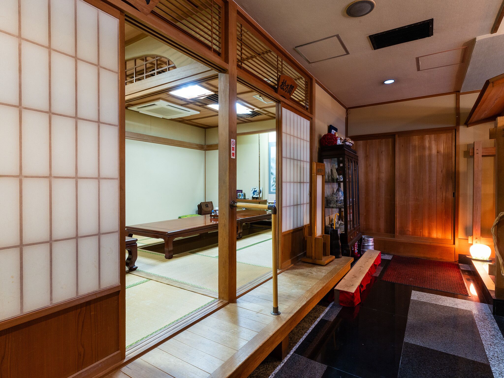 Una habitación tradicional japonesa con suelo de tatami, un puertas correderas y un armario de madera.