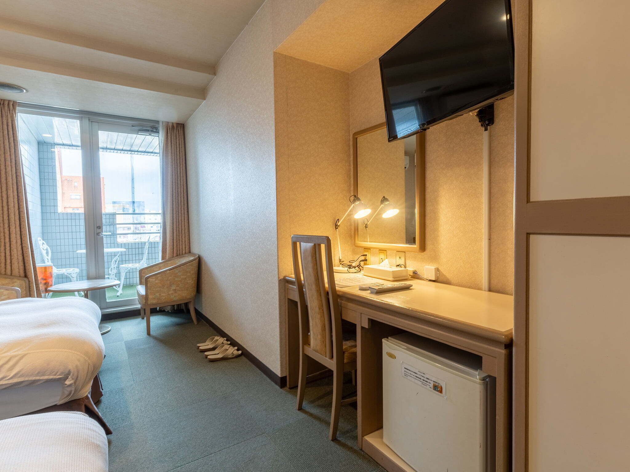 Une chambre d’hôtel équipée d’un lit, d’un bureau, d’une chaise et d’un téléviseur.