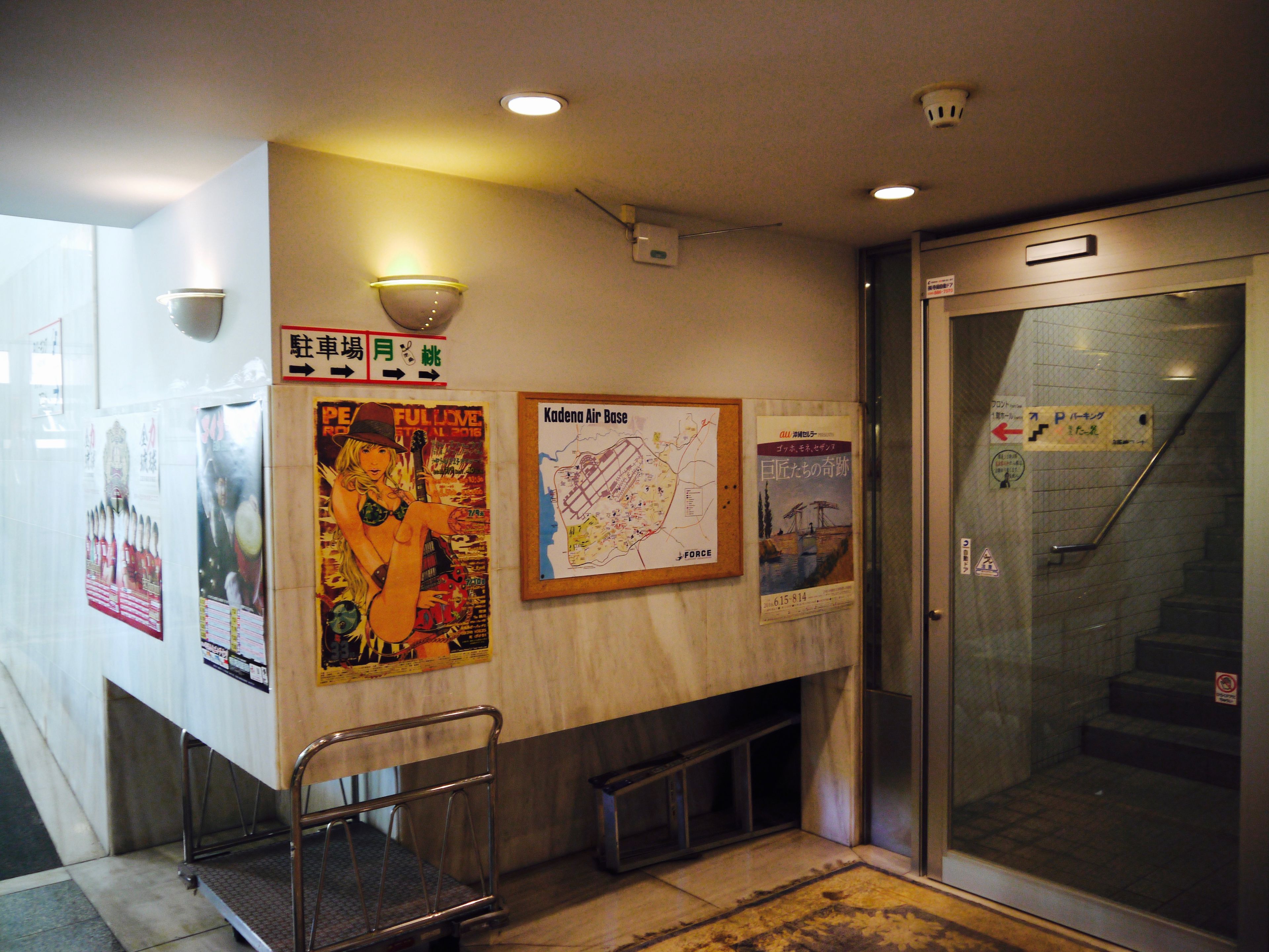 Un espacio público con carteles, un mapa y una escalera que da a un ascensor.