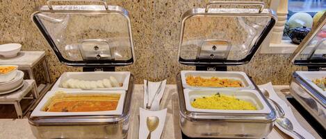 Buffet com opções de comida identificadas, incluindo idli, sambar, tomate upma e poha.