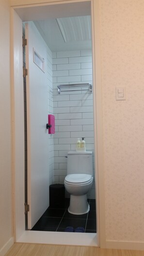 A bathroom with a toilet, a sink, and a shower area. - Nolewaluck (Gyeongju)