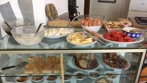 A buffet with various food items including eggs, cheese, and pastries. - Afrodite Hotel (Tinos)
