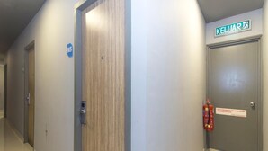 A hallway with a wooden door, a fire extinguisher, and a sign indicating the exit. - i-Hotel Kuala Lumpur (Kuala Lumpur)