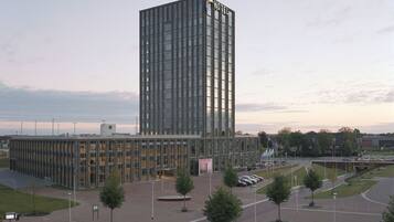 Ett modernt hotell med en hög, rektangulär glasfasad och ett platt tak.