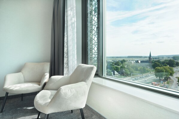 A room with two white armchairs and a large window overlooking a cityscape. - Van der Valk Hotel Nijmegen - Lent (Lent)