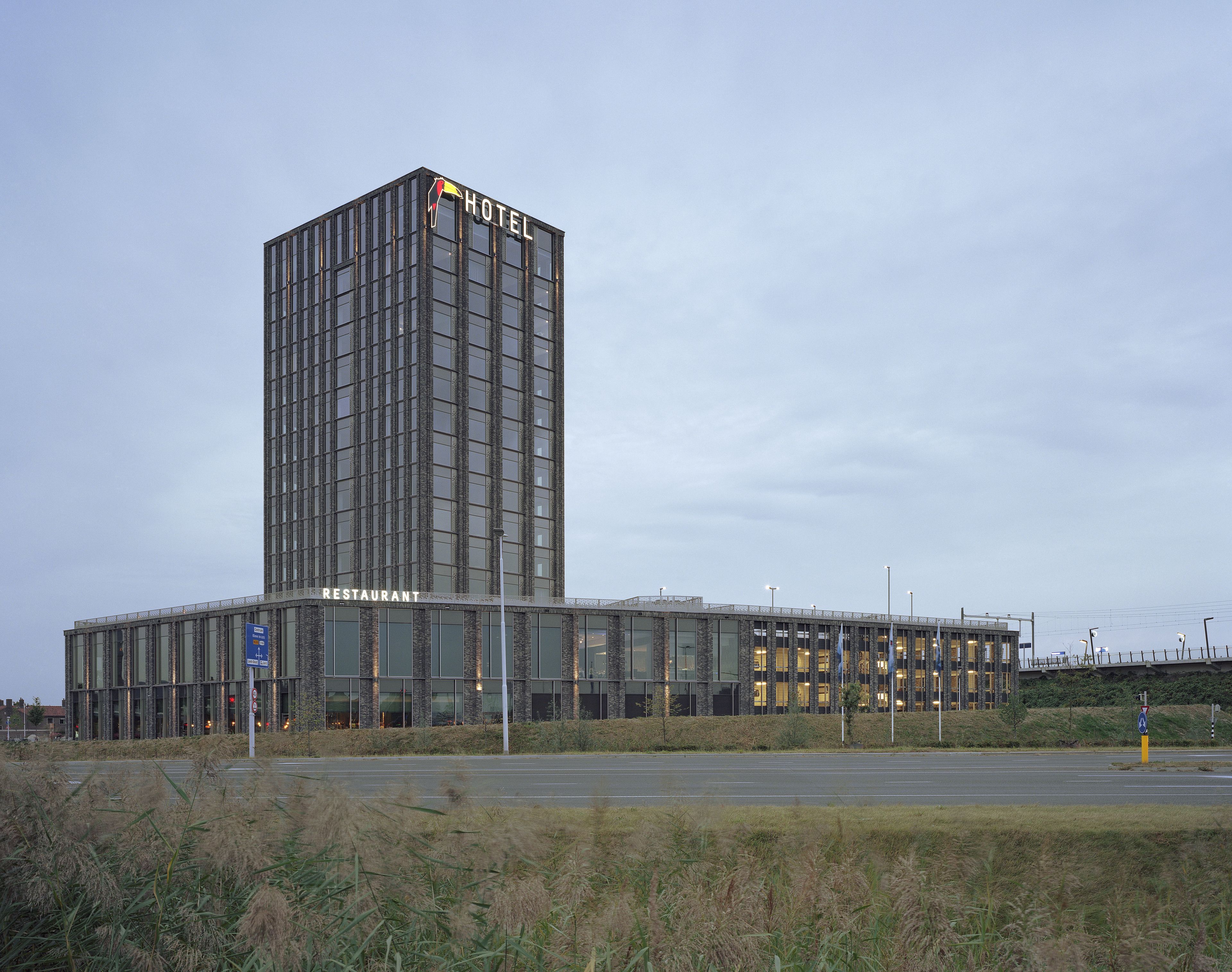 A modern hotel building with a prominent 'HOTEL' sign on top.