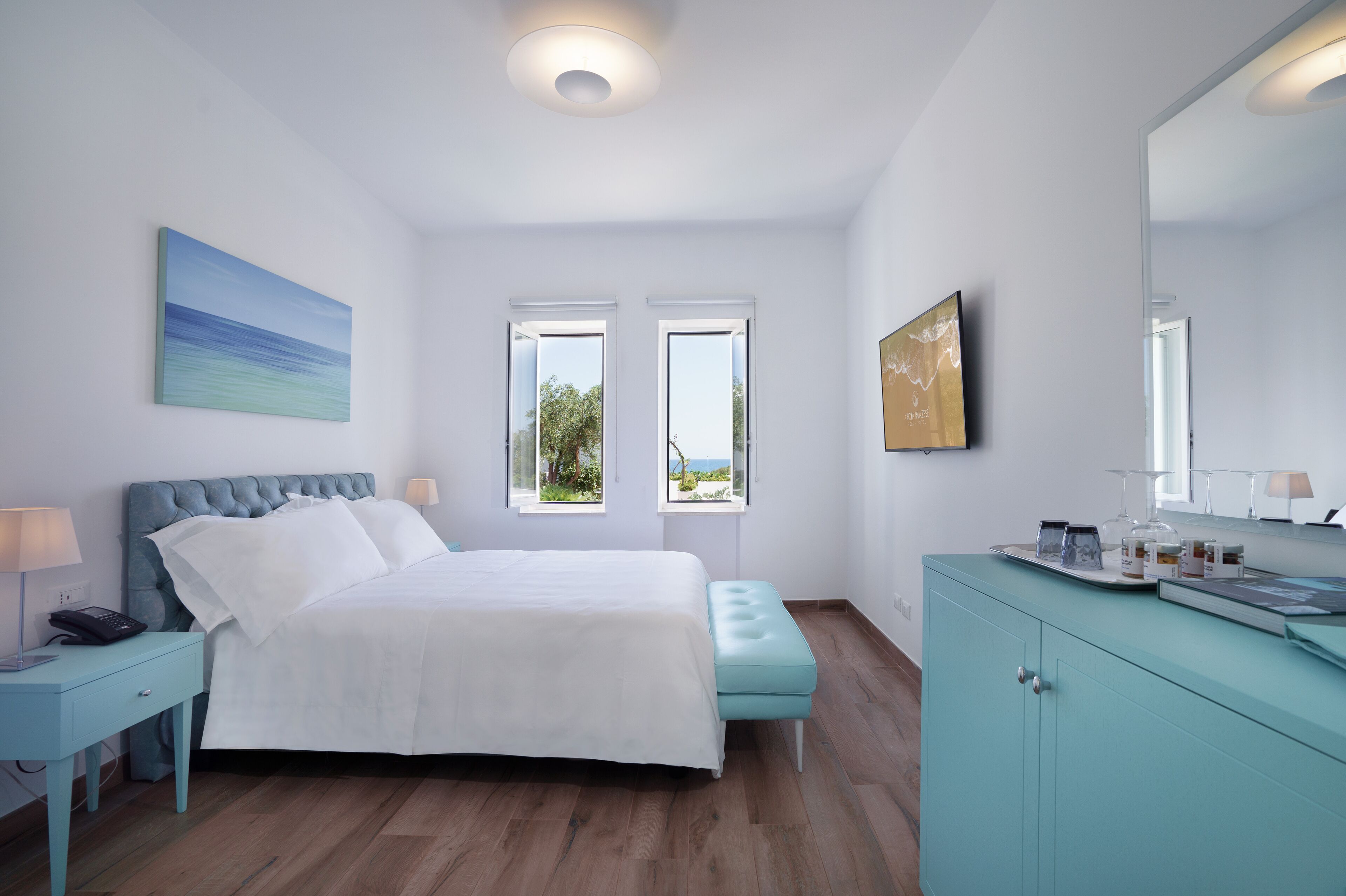Ein Schlafzimmer mit Bett, Nachttisch, Fenster und Blick.