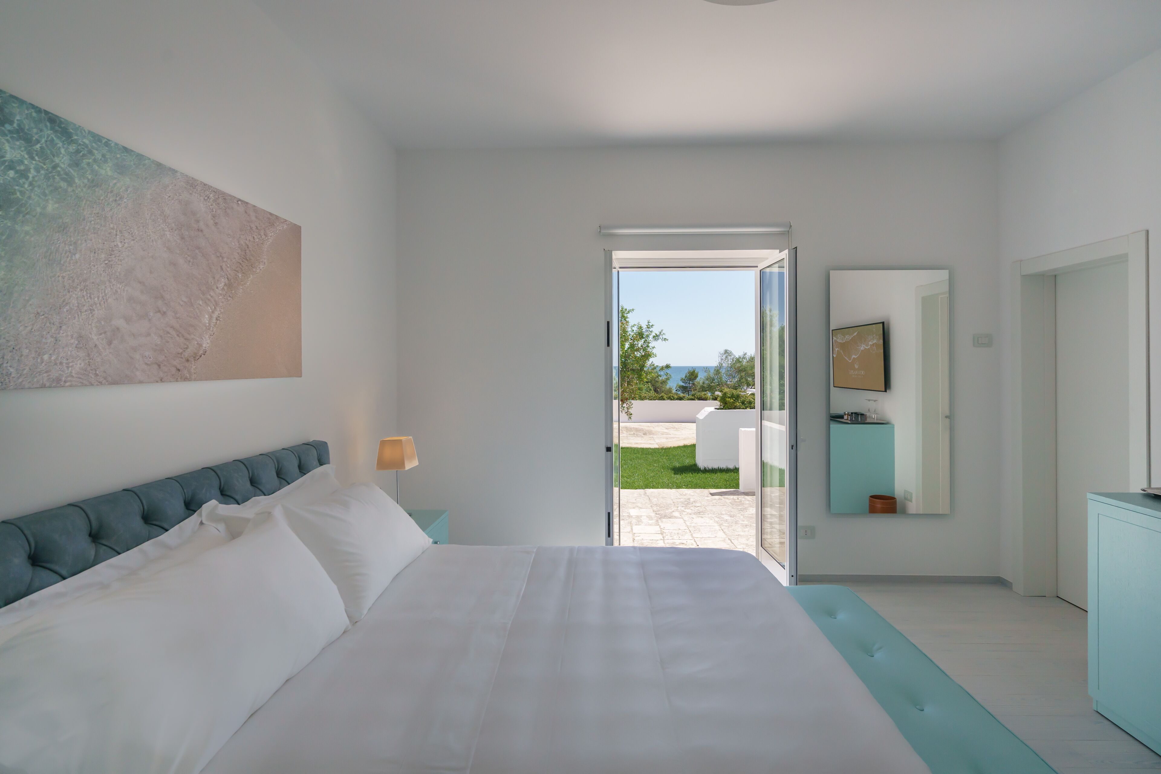 Un dormitorio con cama, un ventanal y vistas al exterior.