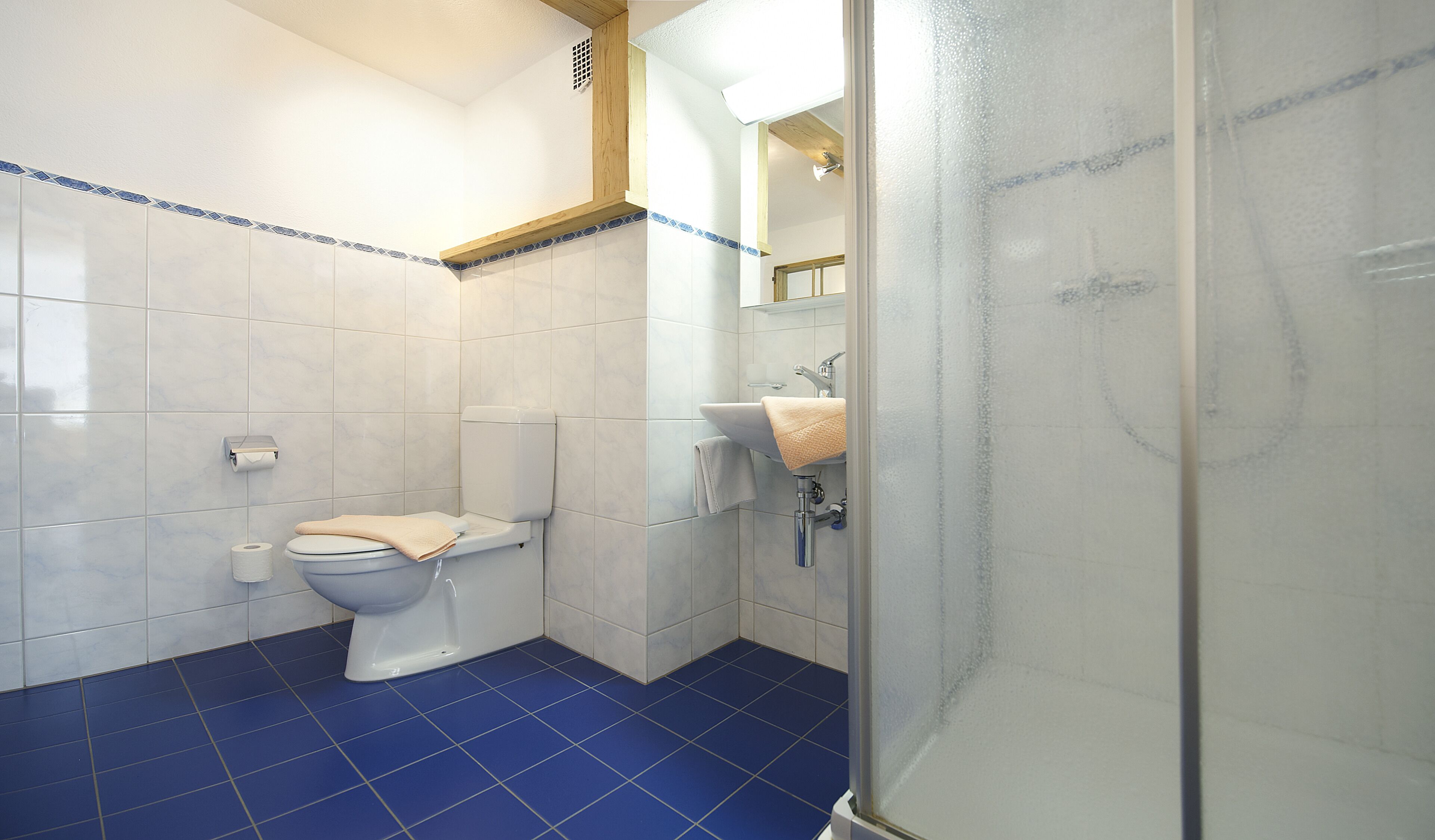 A bathroom with a toilet, sink, and shower.
