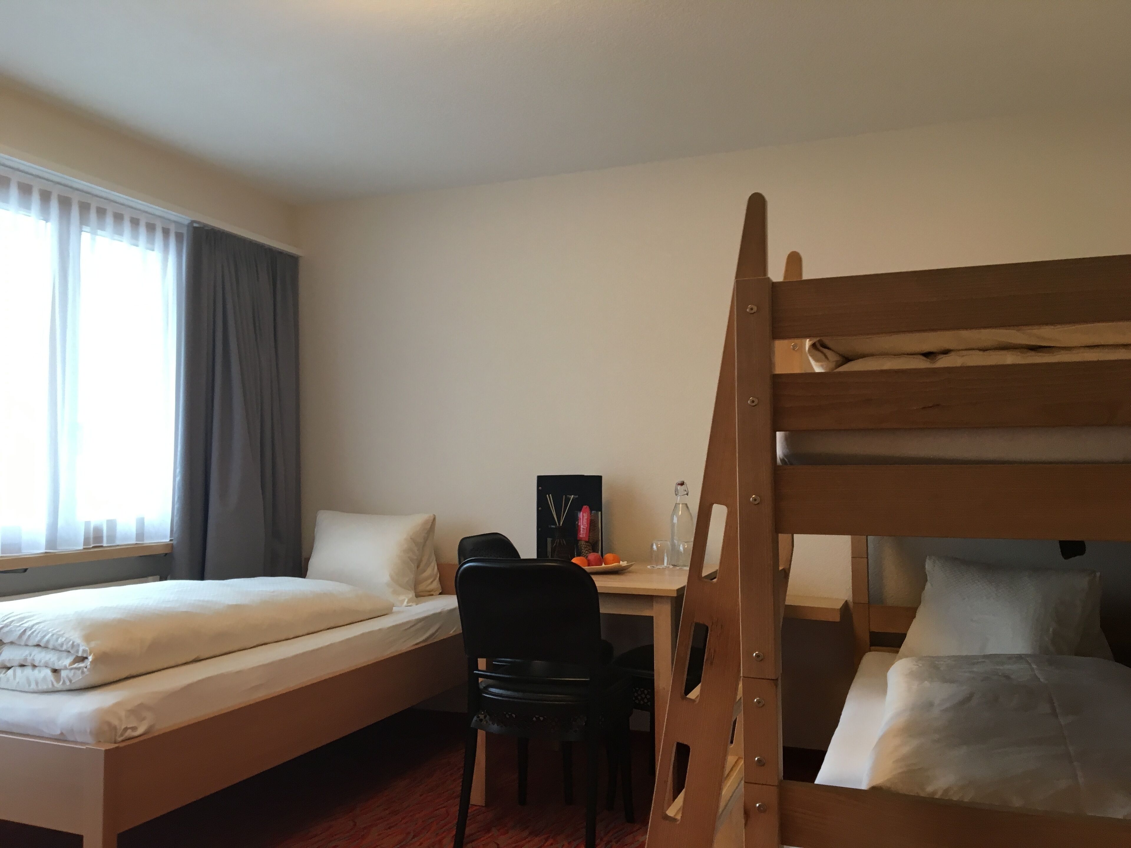 A room with two beds, a desk, and a chair.