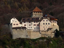 Un edificio al estilo de castillo con varios niveles, muros de piedra y una torre destacada.